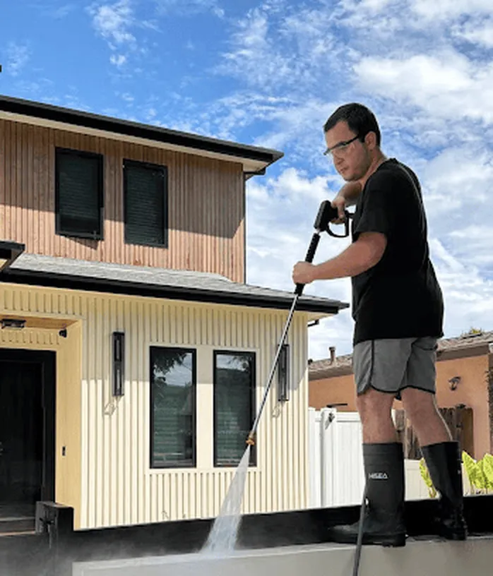 Say Wash It technician pressure washing the top of a front wall at a Los Angeles home