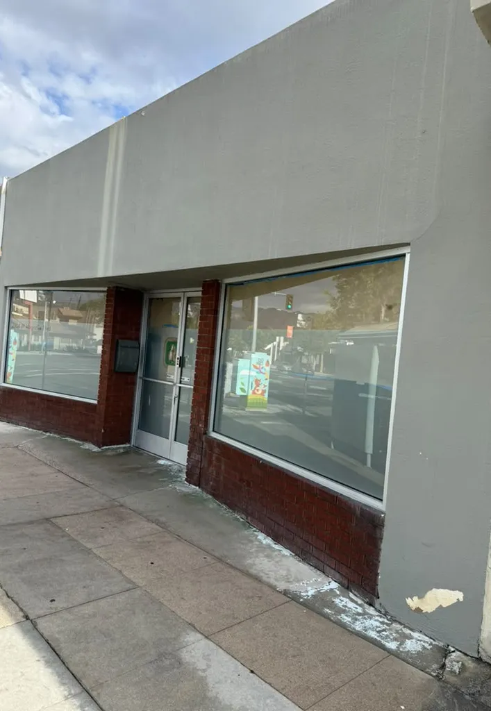 White residue along a storefront brick base and sidewalk in Los Angeles